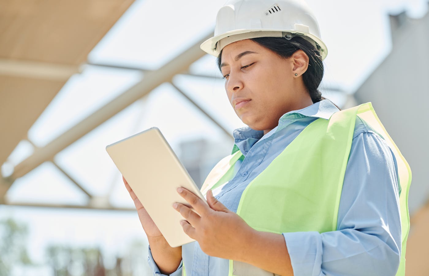 Operatore con tablet che consulta la piattaforma OpSight Maintain in cantiere